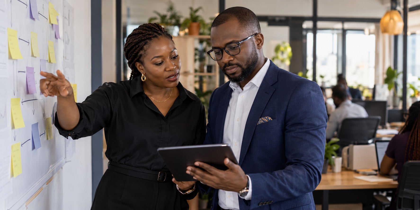 An African business leader and product specialist reviewing a real workflow together
